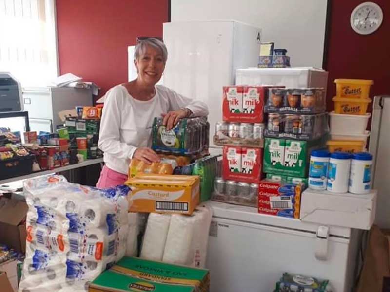 An Age Concern person surrounded with products supplied by the foundation