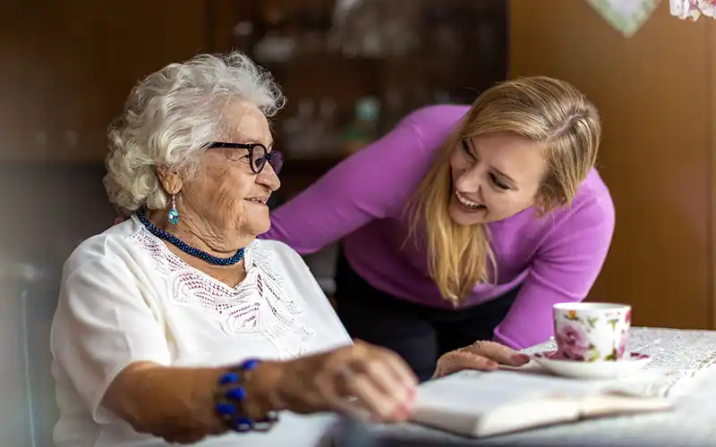 Older woman sat at a table with a younger women
