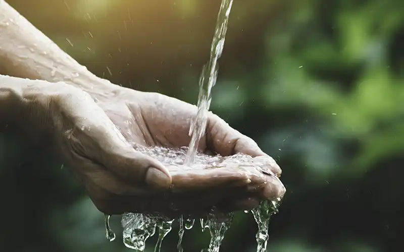 Fresh water pouring onto open hands