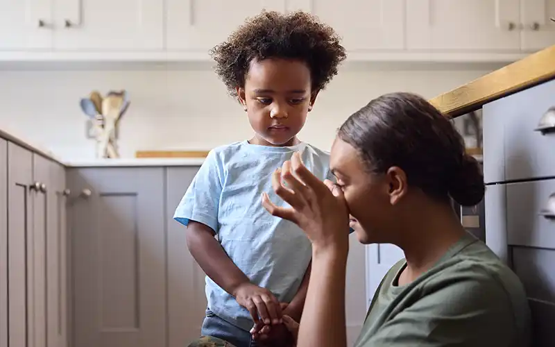 Soldier and young child in a kitchen